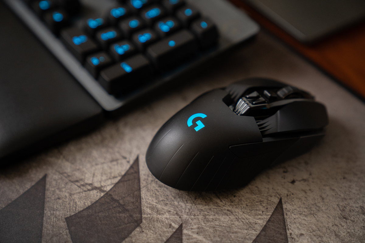 Black Logitech Cordless Computer Mouse on Brown Wooden Table